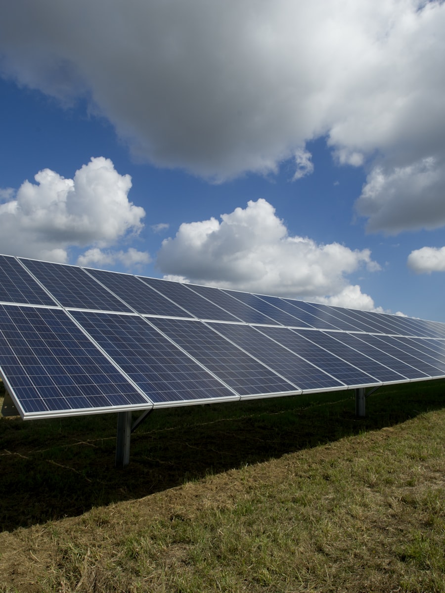 Solar panel array under blue sky with clouds